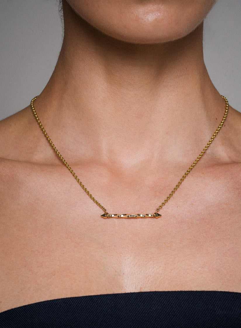 Gold Illusion necklace on a person with a neutral background