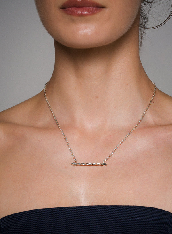 Necklace with a bar pendant on a person against a neutral background